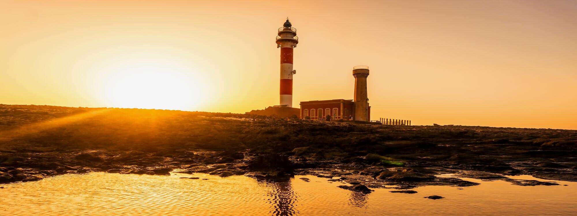 Toston Lighthouse am Meer mit dem reflektierten Leuchtturm Punta Ballena in der Naehe der Stadt El Cotillo - Fuerteventura
